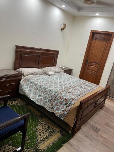 a bedroom with a bed and a wooden headboard at Doctor's house in Lahore