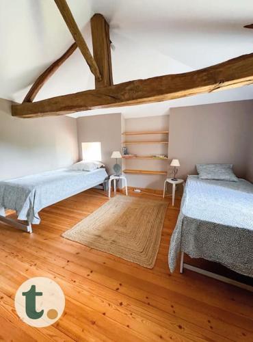 une chambre avec deux lits et un parquet dans l'établissement Tranquiloue - Maison de charme à la campagne - PuyduFou, à Mouchamps