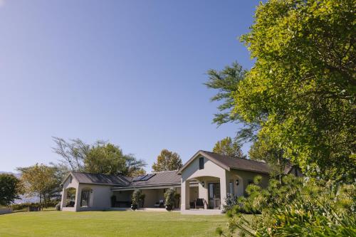 a house with a green lawn at Under Oaks Guesthouse in Paarl