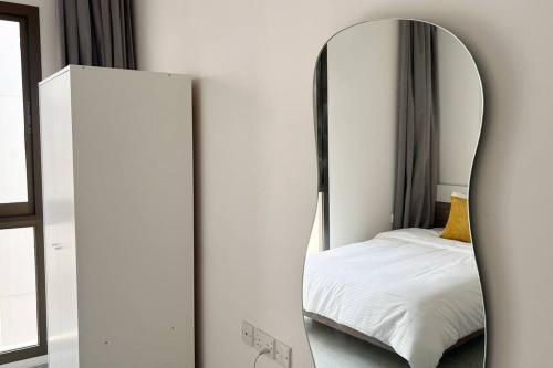 a mirror in front of a bedroom with a bed at Near AlQurum Beach, Free Parking in Muscat