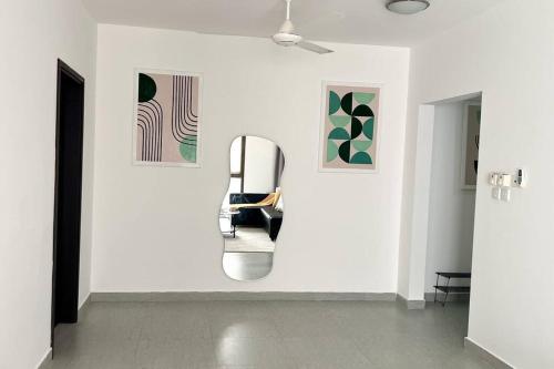 a white room with a chair on a wall with paintings at Near AlQurum Beach, Free Parking in Muscat