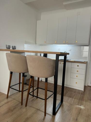 a kitchen with a wooden table and two chairs at Indigo Blue Appartment - City Center in Ohrid