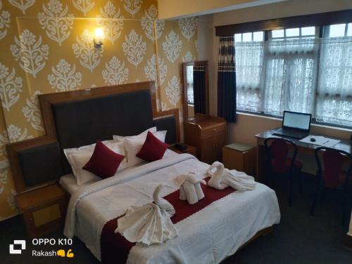 a bedroom with a bed with towel animals on it at PHR North Point Hotel Darjeeling in Darjeeling