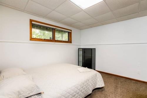 a bedroom with a white bed and a window at Charming 4-Bedroom Retreat Near Notre Dame in South Bend