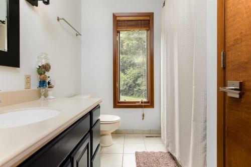 a bathroom with a sink and a toilet and a window at Charming 4-Bedroom Retreat Near Notre Dame in South Bend