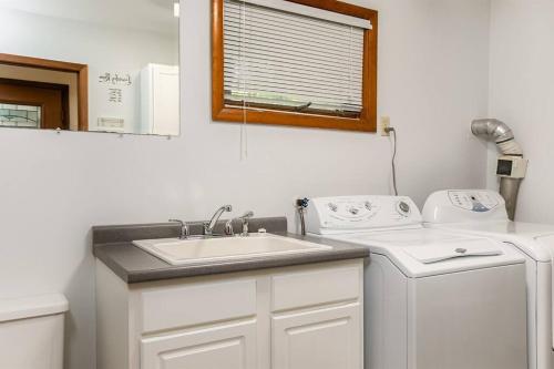 a bathroom with a sink and a washing machine at Charming 4-Bedroom Retreat Near Notre Dame in South Bend