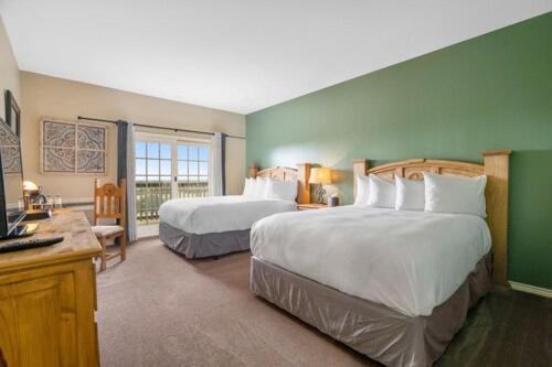 a hotel room with two beds and a television at The Hideout Golf Club & Resort in Lake Brownwood