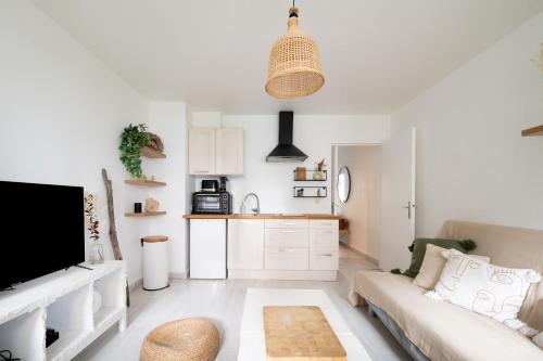 un salon avec un canapé et une cuisine dans l'établissement Appartement Lavoisier - Welkeys, à Puteaux
