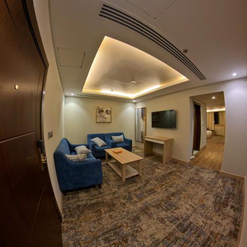 a living room with a blue couch and a table at Samtinn Hotel King Fahad in Riyadh