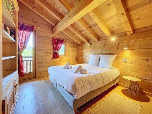 una camera con un letto in una baita di tronchi di Chalet Leonie - 10 pers - proche centre a Les Gets