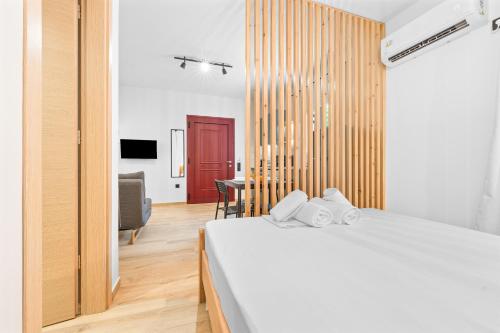 ein Schlafzimmer mit einem weißen Bett und einer roten Tür in der Unterkunft Carina Studios Lefkada 1 in Lefkada Town