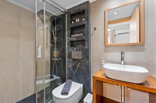 ein Badezimmer mit Waschbecken, Toilette und Dusche in der Unterkunft Carina Studios Lefkada 1 in Lefkada Town