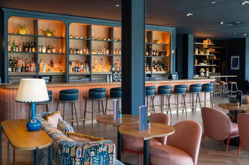 a bar at a hotel with chairs and tables at voco Belfast by IHG in Belfast