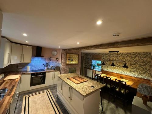 a kitchen with white cabinets and a counter top at Maengwynedd, Llanrhaeadr Ym Mochnant in Oswestry