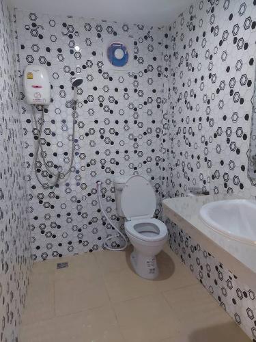 a bathroom with a toilet and a sink at Haad Somboon House in Bang Saphan