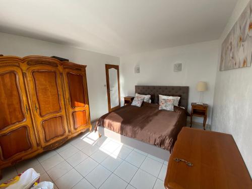 une chambre avec un lit et une armoire en bois dans l'établissement VILLA DOMAINE du DOUC, à Liposthey