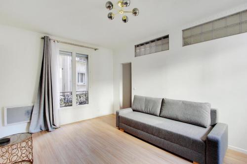 un salon avec un canapé et une fenêtre dans l'établissement Flex Living - whole house - Claude Bernard, à Paris