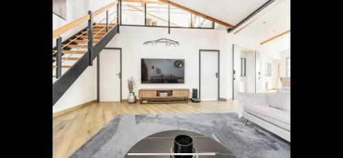 un salon avec un canapé et une télévision dans l'établissement Rooftop Luxury Loft, à Calais