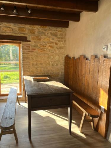 - un bureau et un banc dans une chambre avec fenêtre dans l'établissement La ferme des Soudanières, à Ceyzériat