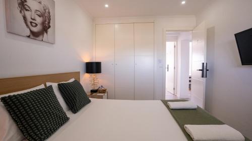 a bedroom with a white bed with black and white pillows at airport room in Lisbon