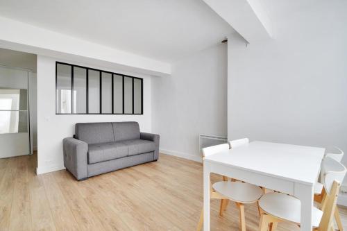 un salon avec un canapé, une table et des chaises dans l'établissement Flexliving - Studio - Saint Antoine, à Paris