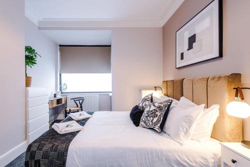 a bedroom with a large white bed with pillows at Hartshill House by YourStays in Stoke on Trent