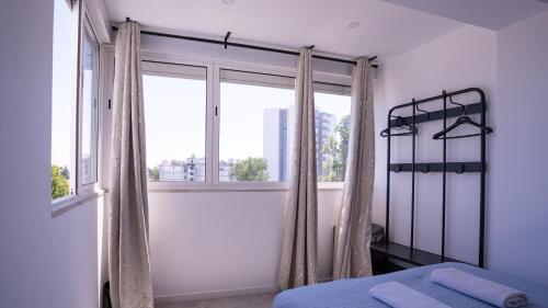 a bedroom with a bed and a large window at airport room in Lisbon