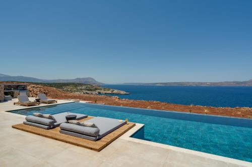 a villa with a swimming pool with a view of the ocean at ARion Aesthesis Superior Villa Heated Pool in Kókkinon Khoríon