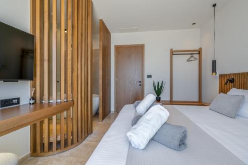 a bedroom with two beds and a flat screen tv at ARion Aesthesis Superior Villa Heated Pool in Kókkinon Khoríon