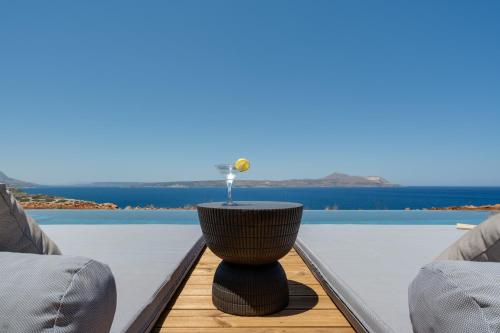 a table on a balcony with a view of the water at ARion Aesthesis Superior Villa Heated Pool in Kókkinon Khoríon
