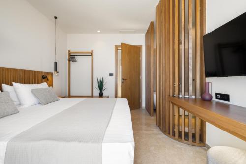 a bedroom with a large bed and a flat screen tv at ARion Aesthesis Superior Villa Heated Pool in Kókkinon Khoríon