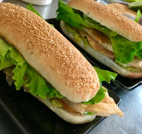 two sandwiches are sitting on a black tray at Gecko Hostel in Siem Reap