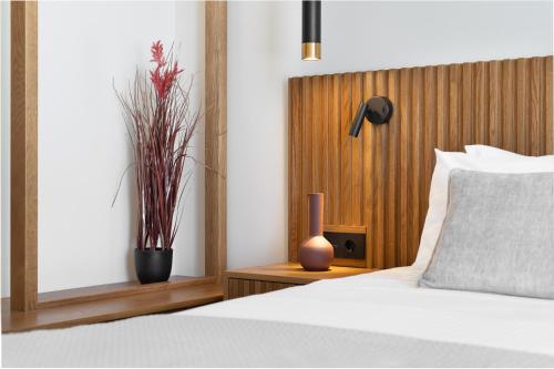 a bedroom with a bed and a vase on a table at ARion Aesthesis Superior Villa Heated Pool in Kókkinon Khoríon
