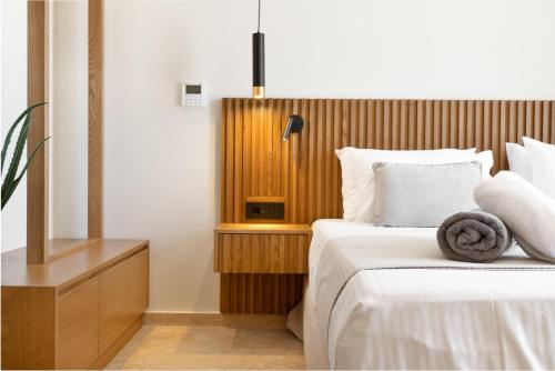 a bedroom with a bed with a wooden headboard at ARion Aesthesis Superior Villa Heated Pool in Kókkinon Khoríon