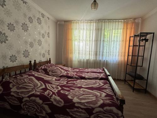 a bedroom with a bed and a window with flowers at Zindisi Forest Haven Retreat in Surami in Surami
