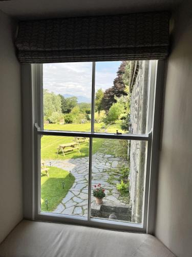 a window in a room with a view of a garden at Maes Y Neuadd Country House in Talsarnau