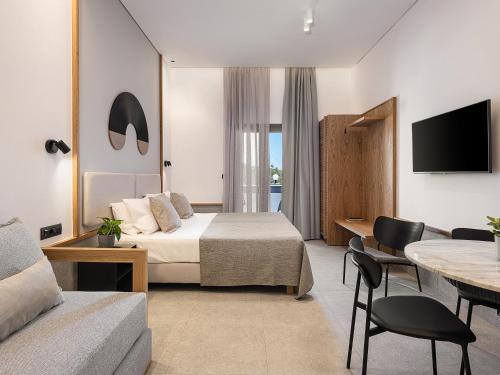 a hotel room with a bed and a table and chairs at Nontas suites in Kato Daratso