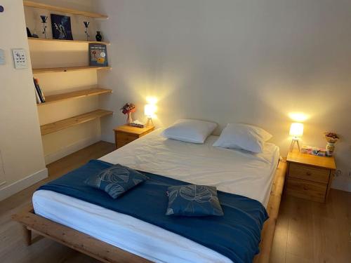 une chambre avec un grand lit avec deux tables de nuit dans l'établissement Coquelicot du Canal Saint-Martin, à Paris