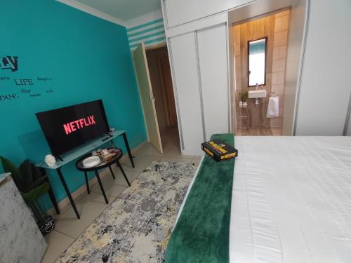 a hotel room with a bed and a tv at Palma spaces in Pretoria