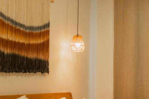 a light hanging from a wall next to a curtain at Cozy apartment with pool in Bacalar Center in Bacalar