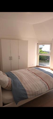 une chambre avec un grand lit avec une fenêtre dans l'établissement Maison Spacieuse avec Jardin, à Gouesnach