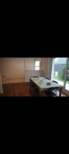 un salon avec une table et une fenêtre dans l'établissement Maison Spacieuse avec Jardin, à Gouesnach