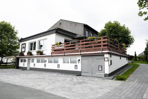 a white building with a balcony on top of it at Gruppenhaus Haus BerchStein in Winterberg