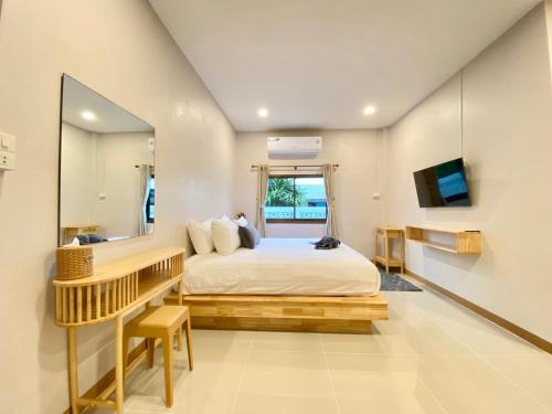a bedroom with a large bed and a mirror at Ban Noen kohlarn in Ko Larn