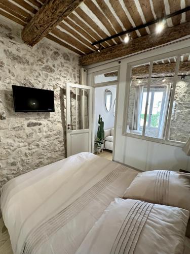 Un dormitorio con una cama y un televisor en la pared. en New Charming Apartment Old Town, en Antibes