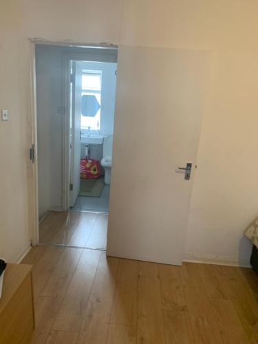 pasillo con puerta blanca y baño en At Apex House, en Dagenham