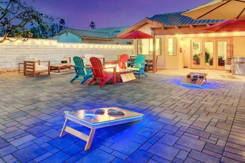 a patio with colorful chairs and a table and an umbrella at Happy Hour in Bermuda Dunes