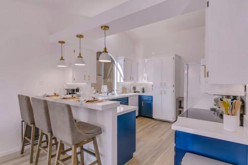 a kitchen with white cabinets and a blue island with bar stools at Happy Hour in Bermuda Dunes