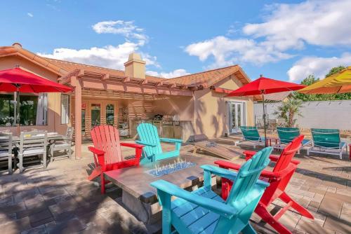 a patio with colorful chairs and tables and umbrellas at Happy Hour in Bermuda Dunes