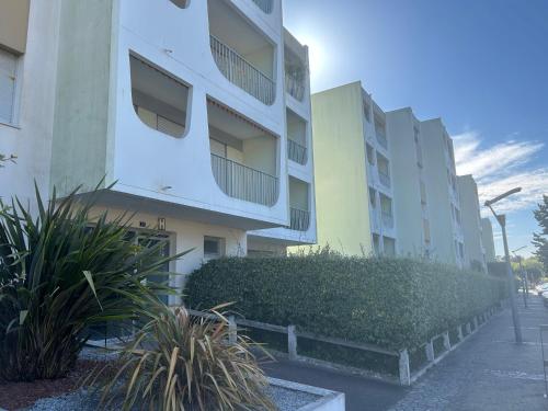 un immeuble d'appartements avec des plantes devant lui dans l'établissement Locations Saint Palais, à Saint-Palais-sur-Mer